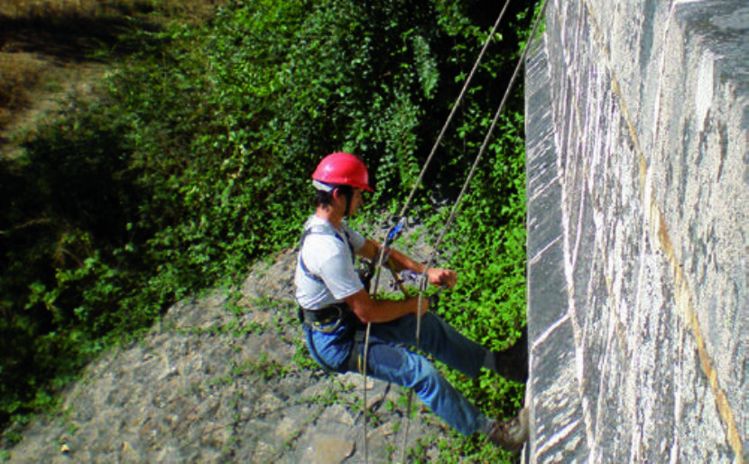 Le cordiste Franck Péan descend sur corde sur les quarts de cône d'un pont.